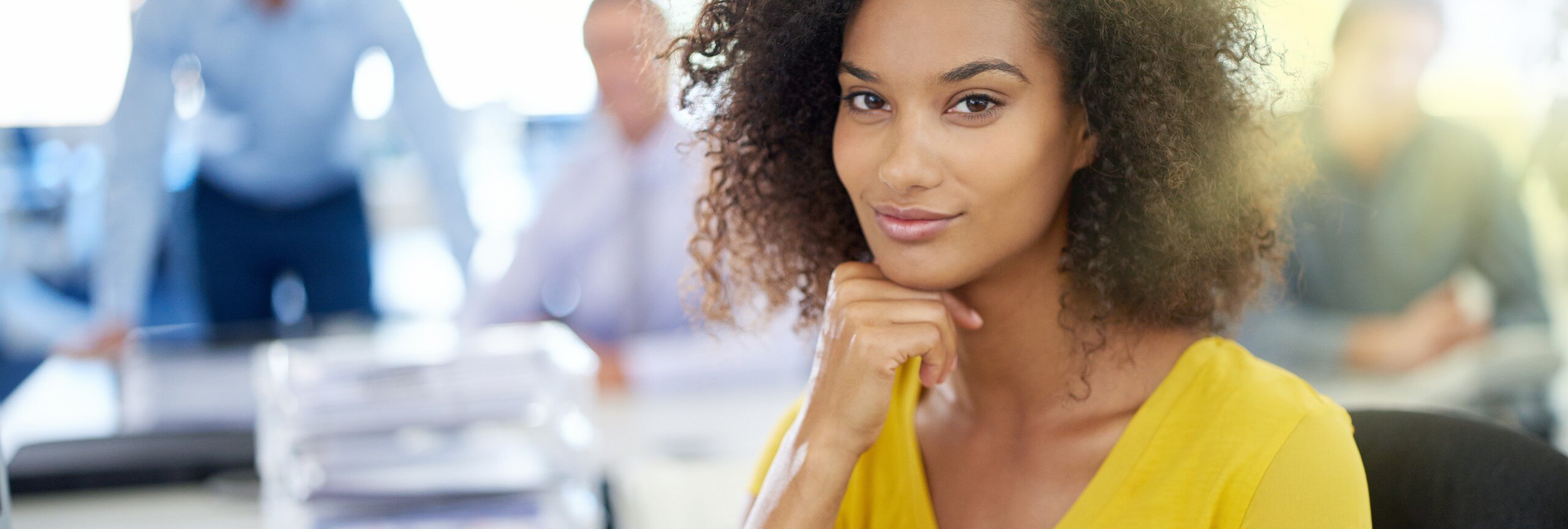 A woman with curly hair focused on her computer, representing textkernel's efficient talent acquisition solutions.